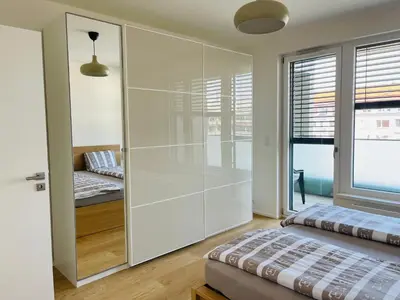 a bedroom with a glass partition with a bed and a window at Nová Nuselská in Prague