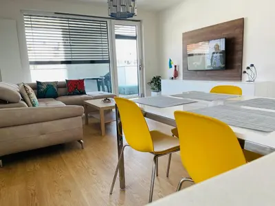 a living room with a table and yellow chairs at Nová Nuselská in Prague