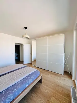 a bedroom with a bed and a large white cabinet at Nová Nuselská in Prague