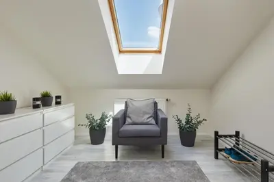 a living room with a chair and a skylight at Prague Days - Bright Apartments - Fast WiFi - Quiet Area in Prague