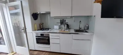 a white kitchen with a stove and a sink at Anenska by Charles Bridge 2 in Prague