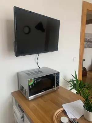 a television on top of a microwave oven on a table at Anenska by Charles Bridge 1 in Prague
