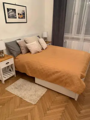 a bedroom with a large bed with orange sheets and pillows at Anenska by Charles Bridge 1 in Prague