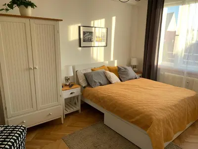 a bedroom with a bed and a cabinet and a window at Anenska by Charles Bridge 1 in Prague