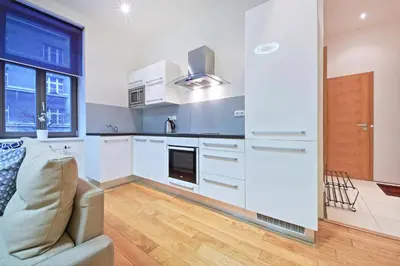 a living room with a couch and a kitchen at Family Apartments in Prague