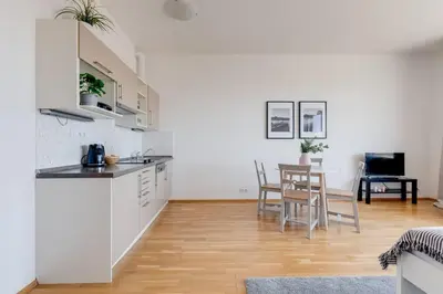 a kitchen and living room with a table and chairs at JT's Apartments Korunní str. in Prague