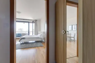 a bedroom with a bed and a room with a door at JT's Apartments Korunní str. in Prague