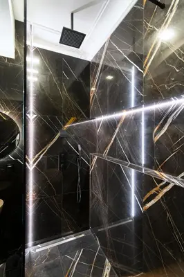 a bathroom with black marble walls and a shower at Antique Glam Apartment in Old Town Prague in Prague