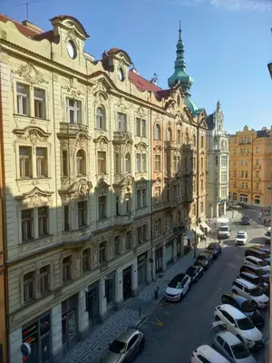 a large building with cars parked in a parking lot at Antique Glam Apartment in Old Town Prague in Prague