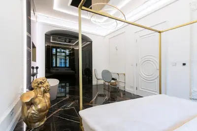 a living room with a bed and a table at Antique Glam Apartment in Old Town Prague in Prague