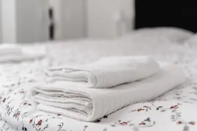 a pile of towels sitting on top of a bed at Penzion Grado Davle in Davle