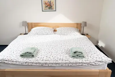 a bedroom with a bed with towels on it at Penzion Grado Davle in Davle
