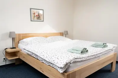 a bedroom with a bed with two towels on it at Penzion Grado Davle in Davle
