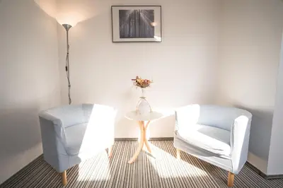 a room with two chairs and a table and a lamp at Penzion Grado Davle in Davle