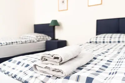 two beds with towels sitting on top of a bed at Penzion Grado Davle in Davle