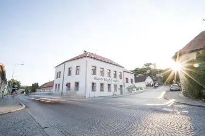 a street with a white building on the side of a road at Penzion Grado Davle in Davle