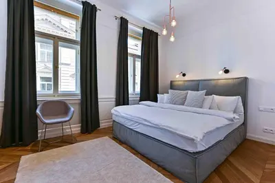 a bedroom with a large bed and a chair at Wishlist Prague Residences Malá Strana in Prague