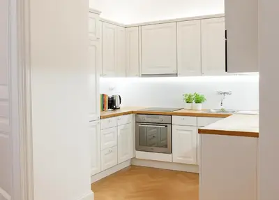 a white kitchen with white cabinets and a sink at Wishlist Prague Residences Malá Strana in Prague