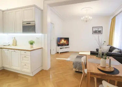 a kitchen and a living room with a table at Wishlist Prague Residences Malá Strana in Prague
