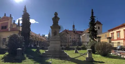 a statue in the middle of a courtyard with buildings at Rodinný dům pod Hazemburkem in Libochovice