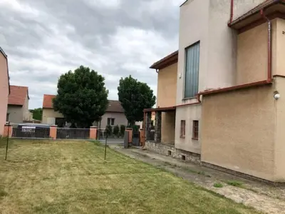 a house with a yard next to a building at Rodinný dům pod Hazemburkem in Libochovice