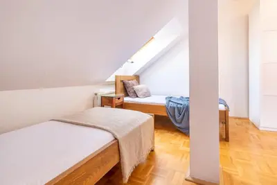 a attic room with two beds and a staircase at Templová - Old Town Large Apartment with Terrace in Prague