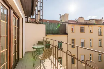 a balcony with a table and chairs on a building at Templová - Old Town Large Apartment with Terrace in Prague