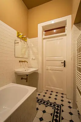 a bathroom with a tub and a sink and a door at 4 Bedrooms 130m2 apartment at the Main City Square in Prague
