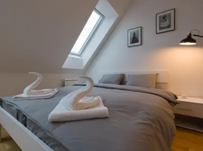 a bedroom with two swans towels on a bed at BARTAL APARTMENTS - Prague in Prague