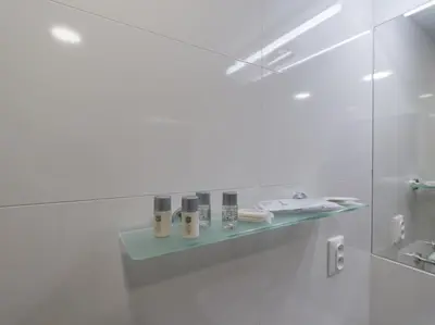 a white bathroom with a glass shower stall at BARTAL APARTMENTS - Prague in Prague
