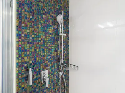 a shower in a bathroom with a mosaic wall at BARTAL APARTMENTS - Prague in Prague