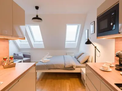 a bedroom with a bed in a room with skylights at BARTAL APARTMENTS - Prague in Prague