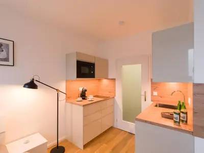 a kitchen with white cabinets and a lamp in it at BARTAL APARTMENTS - Prague in Prague