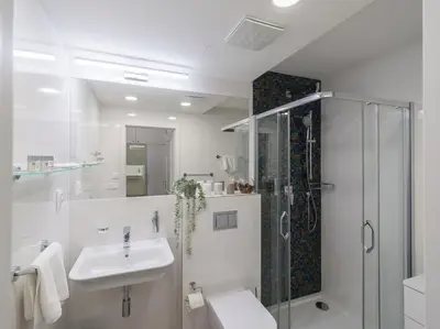 a white bathroom with a sink and a shower at BARTAL APARTMENTS - Prague in Prague