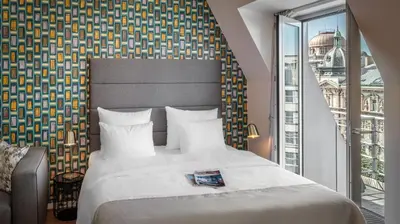 a bedroom with a large bed and a large window at VN17 Rooftop Suites by Adrez in Prague