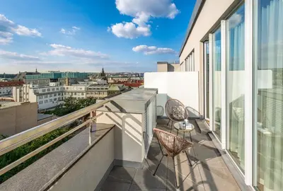 a balcony with two chairs and a view of a city at VN17 Rooftop Suites by Adrez in Prague