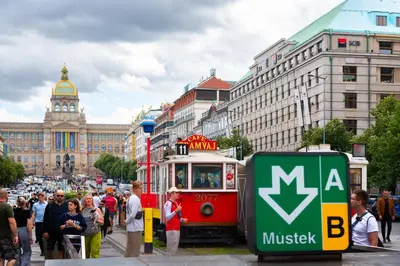 a group of people standing around a tram in a city at VN17 Rooftop Suites by Adrez in Prague