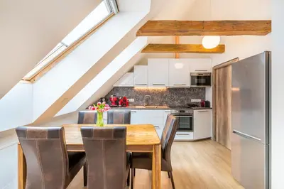 a kitchen and dining room with a wooden table and chairs at Masná 20 - Old Town Residence in Prague