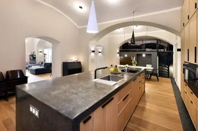 a kitchen with a counter top and a living room at Design Loft 2 Minutes to Wenceslas square in Prague