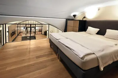 a bedroom with a large bed and a hallway at Design Loft 2 Minutes to Wenceslas square in Prague