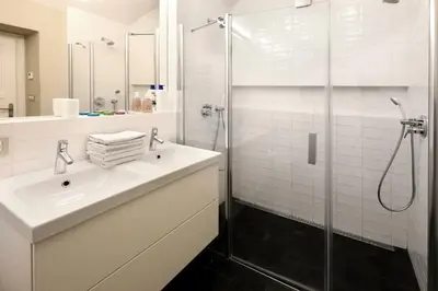 a white bathroom with a sink and a shower at Design Loft 2 Minutes to Wenceslas square in Prague
