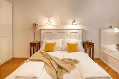 a bedroom with a large white bed with two yellow pillows at Templová - Old Town Apartments in Prague