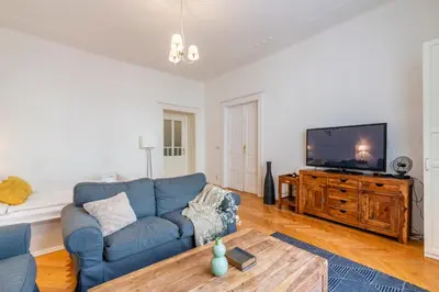 a living room with a blue couch and a flat screen tv at Templová - Old Town Apartments in Prague