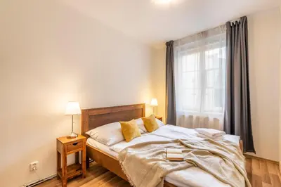 a bedroom with a bed with yellow pillows and a window at Templová - Old Town Apartments in Prague