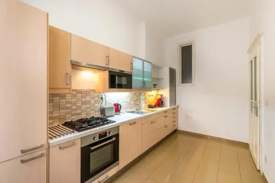 a kitchen with wooden cabinets and a stove top oven at Templová - Old Town Apartments in Prague