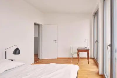 a bedroom with a bed and a desk and a chair at Prague Days - Spacious Apartment with Balcony by the Vltava river in Karlin in Prague