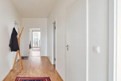 a hallway of a home with white walls and wooden floors at Prague Days - Spacious Apartment with Balcony by the Vltava river in Karlin in Prague