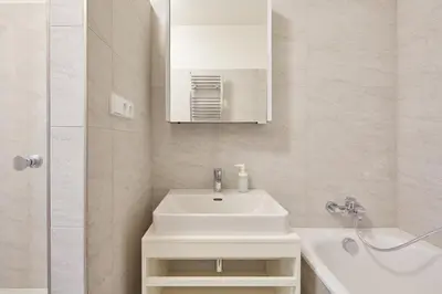 a bathroom with a white sink and a mirror at Prague Days - Spacious Apartment with Balcony by the Vltava river in Karlin in Prague