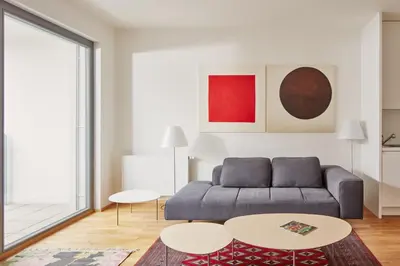 a living room with a couch and two tables at Prague Days - Spacious Apartment with Balcony by the Vltava river in Karlin in Prague
