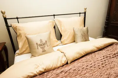 a bed with white pillows and a black frame at Vila Walter & Son in Poděbrady